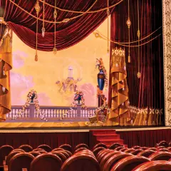 Scena Teatru Wielkiego w Warszawie, bogato zdobiona, z aksamitnymi kotarami i malowidłem przedstawiającym anioły.