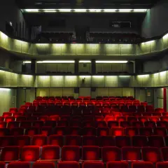 Puste czerwone fotele w teatrze Bagatela, widok na lożę i balkon.