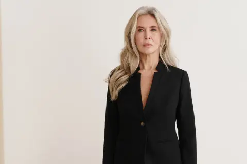 Elegancka kobieta w czarnym żakiecie, idealna stylizacja, jeśli zastanawiasz się, jaka sukienka do teatru.