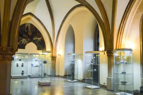 Wnętrze muzeum sztuki mieszczańskiej we Wrocławiu. W salach z arkadowymi sklepieniami wyeksponowano ceramikę i naczynia w szklanych gablotach.