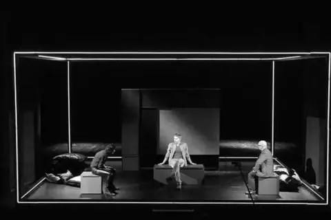 Trzech mężczyzn na scenie, w minimalistycznej scenografii. Spektakl "Ludzie inteligentni" wciąga widza w refleksję nad ludzką naturą.