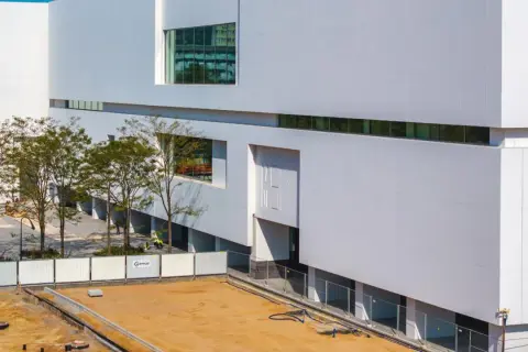 Nowoczesny budynek muzeum sztuki współczesnej w Warszawie, z białymi, geometrycznymi fasadami i dużymi oknami.