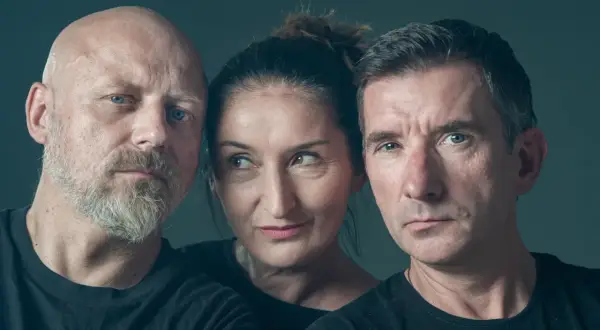 Trzy osoby w czarnych koszulkach. Z lewej łysy mężczyzna z brodą, w środku kobieta, z prawej mężczyzna z krótkimi włosami. Skład kabaretu Mumio.