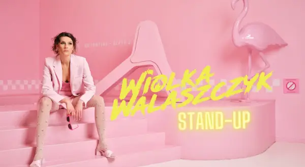 Wiola Walasczyk gotowa na stand-up. Siedzi na różowych schodach obok flaminga.