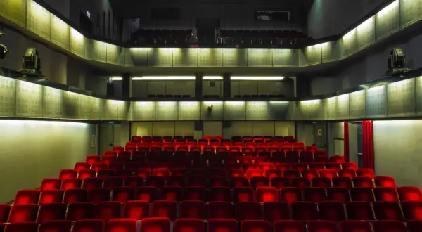 Puste czerwone fotele w teatrze Bagatela, widok na lożę i balkon.