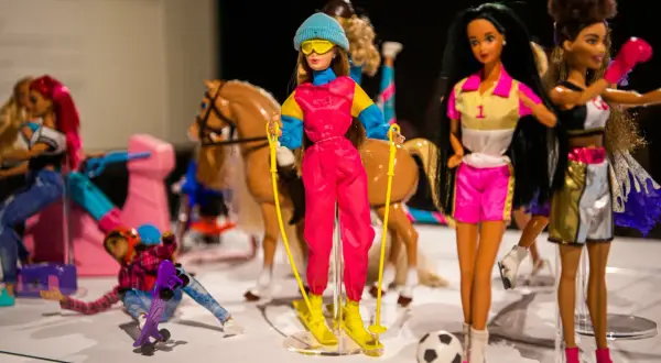 Wystawa muzeum sztuk użytkowych Barbie: lalki w strojach narciarskich, sportowych i jeździeckich, z koniem i piłką.