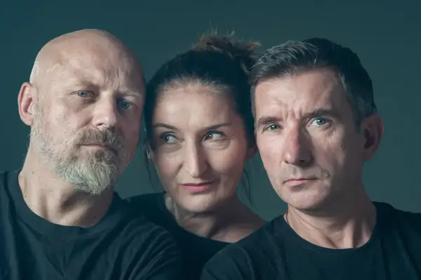 Trzy osoby w czarnych koszulkach. Z lewej łysy mężczyzna z brodą, w środku kobieta, z prawej mężczyzna z krótkimi włosami. Skład kabaretu Mumio.