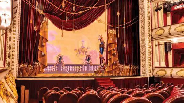 Scena Teatru Wielkiego w Warszawie, bogato zdobiona, z aksamitnymi kotarami i malowidłem przedstawiającym anioły.